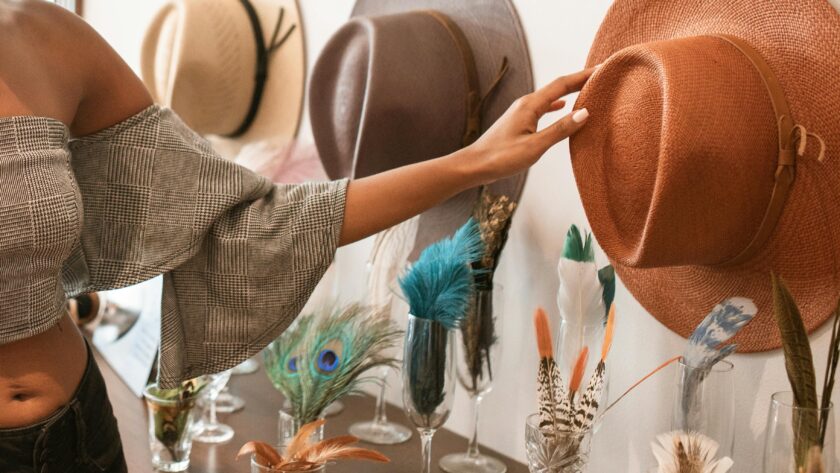 kobieta sięgająca po kapelusz