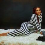 kobieta w ubraniu w czarno-białe paski leżąca na białym shaggy dywanie