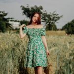 Dziewczyna w kwiecistej sukience na polu zbóż